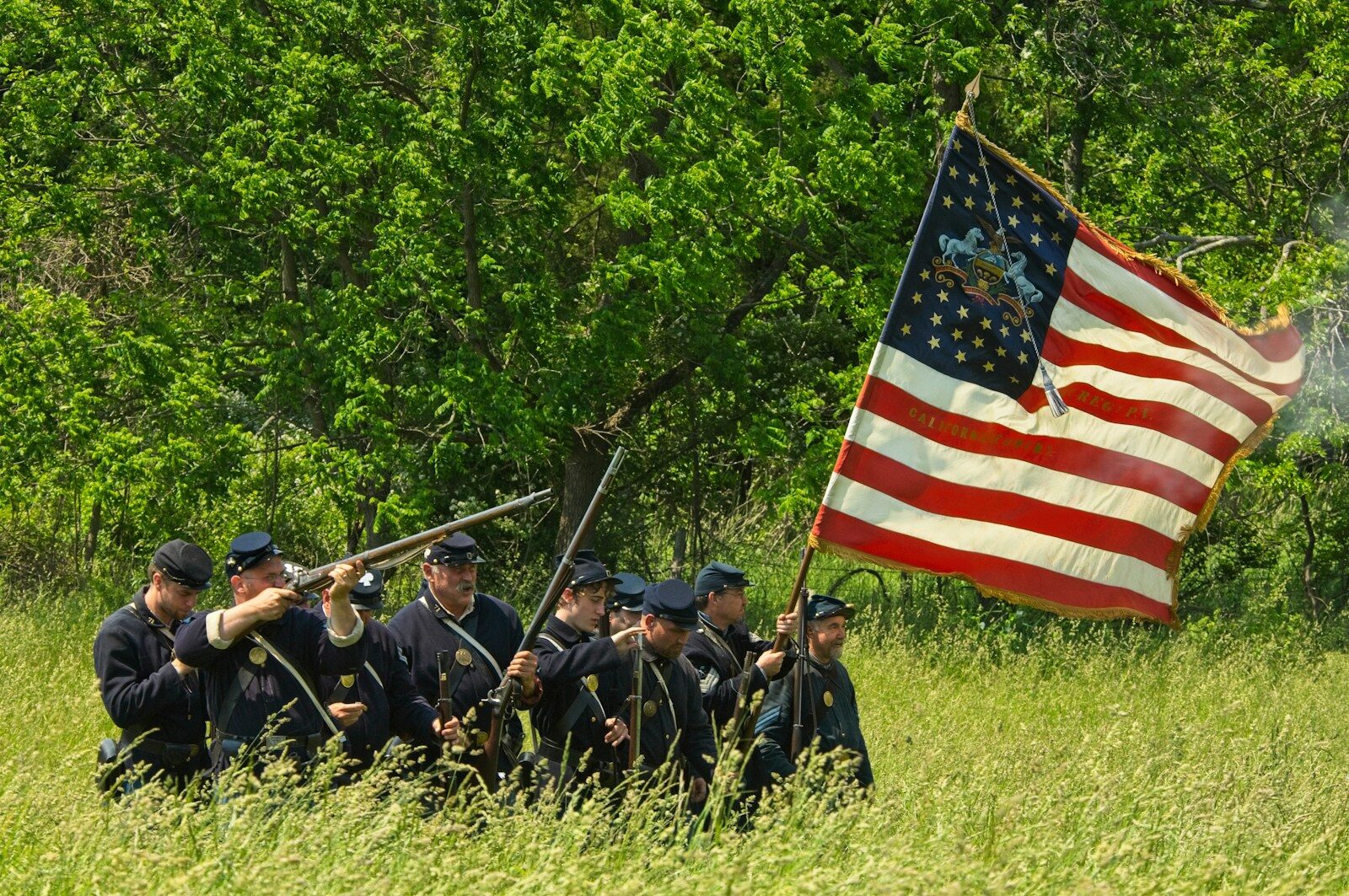 people holding us a flag on green grass field during daytime